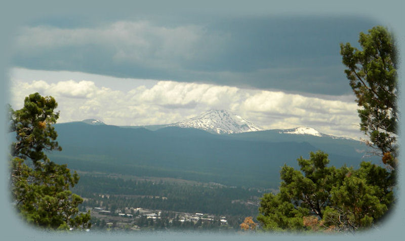 
bachelor butte awaiting the storm, photographed from atop pilot butte in bend, oregon, central oregon's gateway: find alpine lakes, skiing, hiking trails, volcanoes, newberry national volcanic monument: benham falls, wild and scenic deschutes river, lava cast forest, lava river cave, lava butte, lava lands, paulina and east lakes, newberry crater; lapine state park, and more.